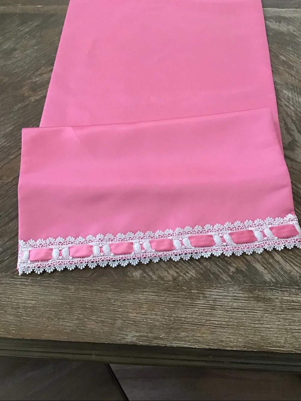 Table runner features a decorative white lace and ribbon trim